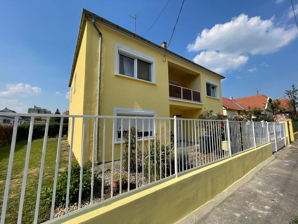 Gelbes Unterkunftsgebäude mit Eingang und Terrasse – GLOBEFOX