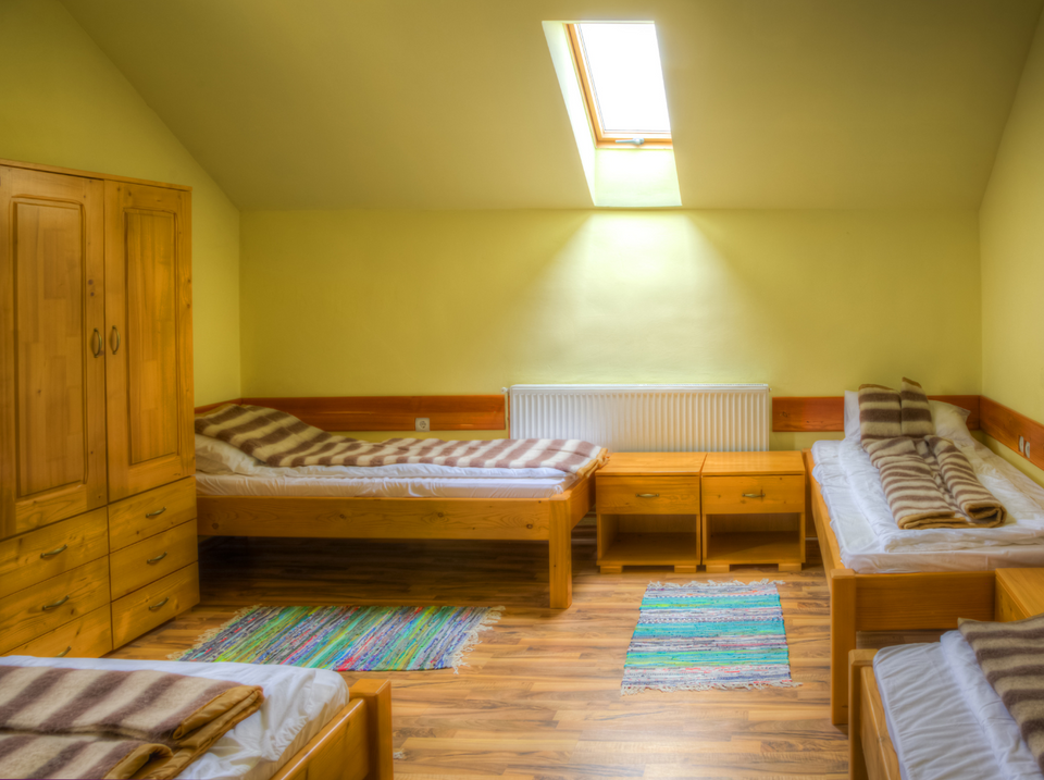 Zimmer mit Holzbett und Schrank – GLOBEFOX